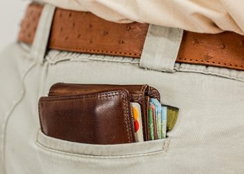 Bulging leather wallet with cards and notes sticking out of a back pocket