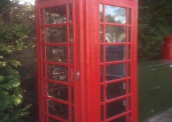 Traditional red telephone box with book swop signs