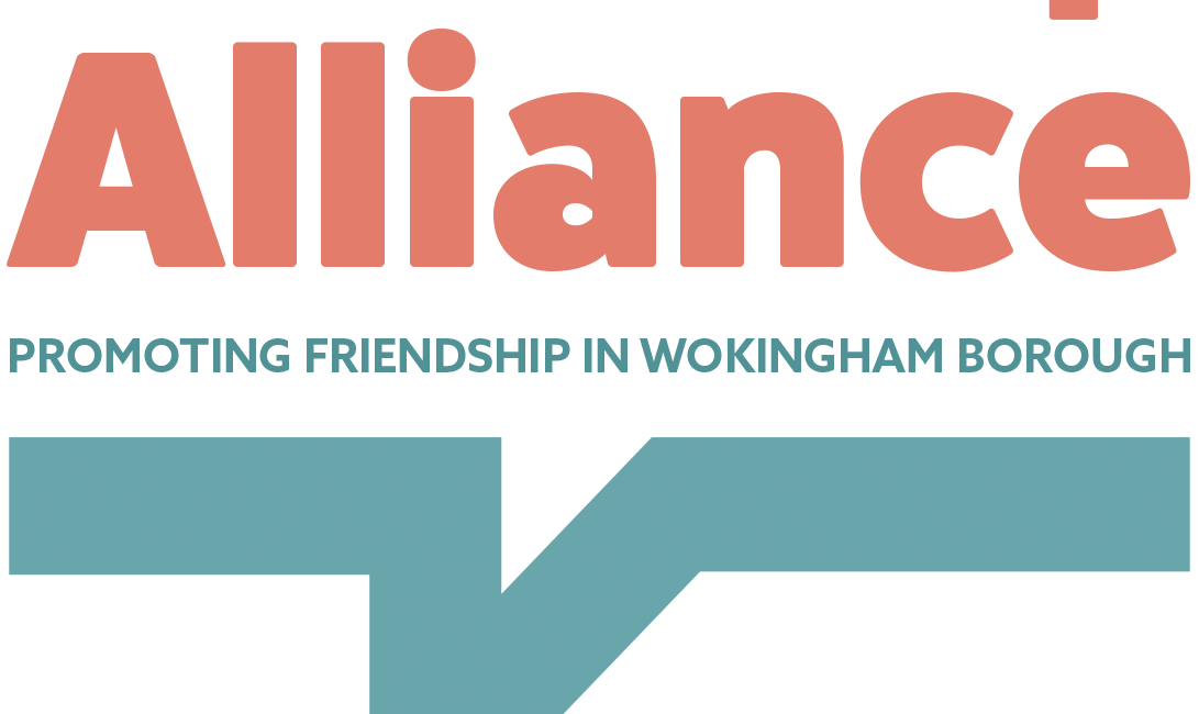 Friendship Alliance logo with red writing on a grey and white checked background