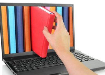 Laptop with hand taking a red book out of the screen