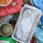 empty foil and plastic trays, cans, plastic bottle and cardboard box for recycling