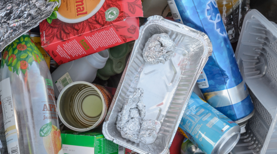 empty foil and plastic trays, cans, plastic bottle and cardboard box for recycling